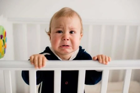 Baby boy crying in his crib
