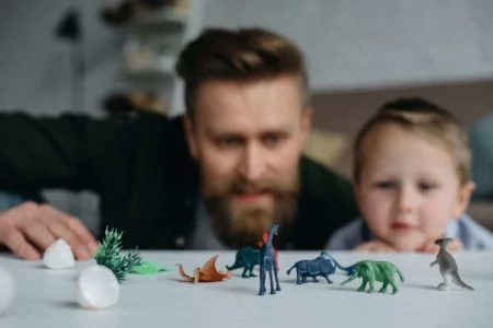 Father and son playing with dinosaur toys