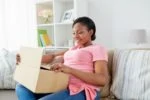 Pregnant woman smiling while opening a gift box