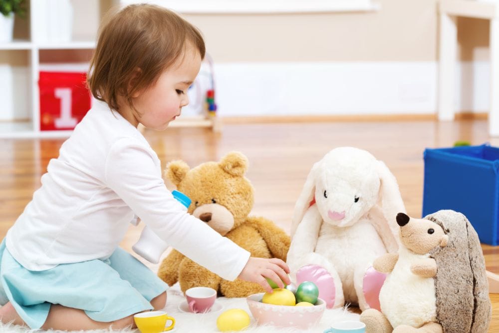 Little girl playing with stuffed animals