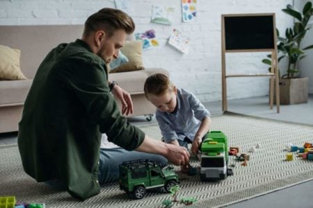 Father and son playing with toy cars