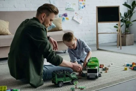 Father and son playing with toy cars