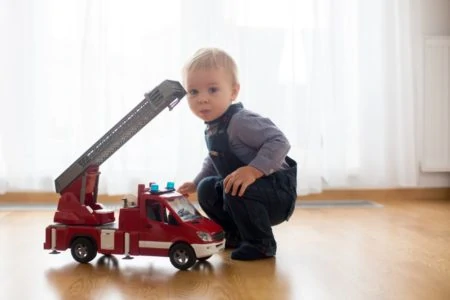 Toddler playing with toy fire truck