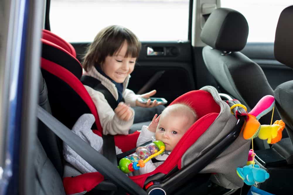 Toddler and baby boy in car seats