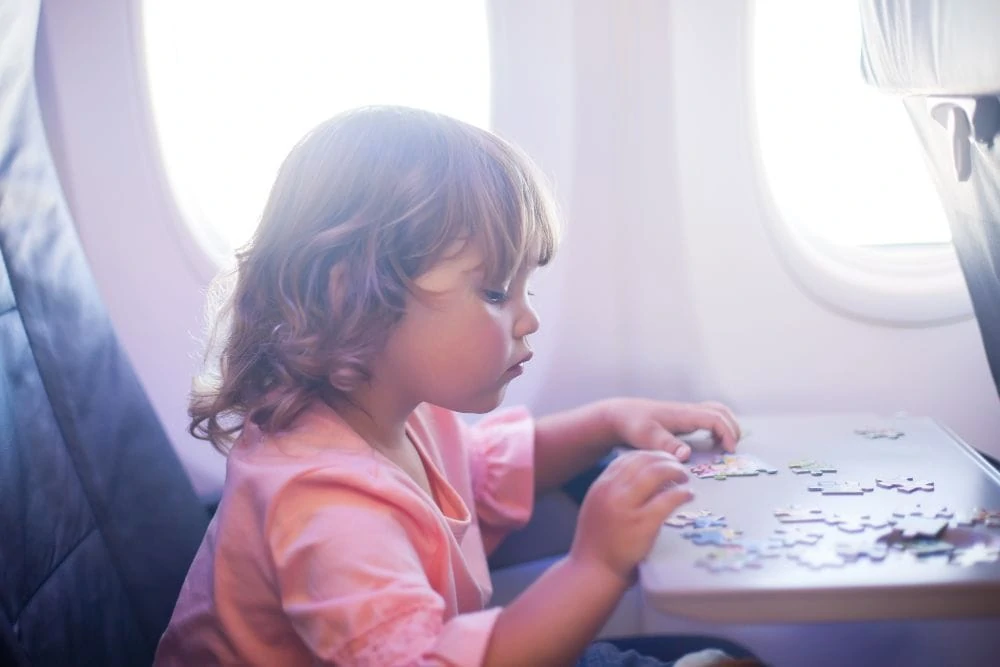 Toddler playing with a puzzle in a plane