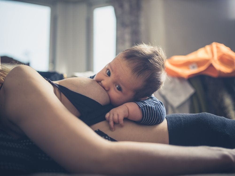 Baby breastfeeds while mom sleeps