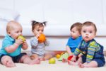 Four babies playing with toys
