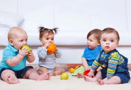 Four babies playing with toys