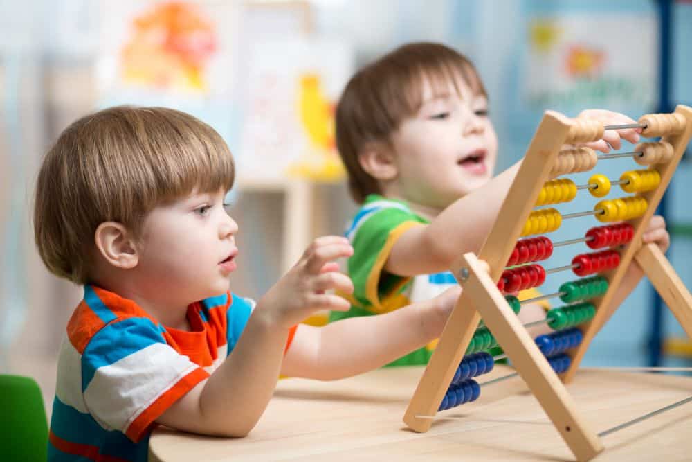 Two cute boys playing with abacus toy