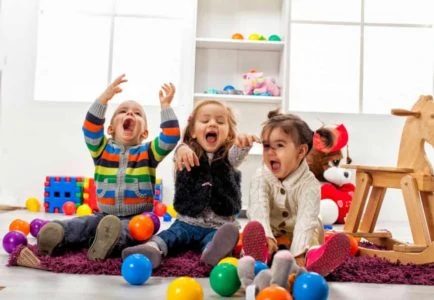 Three little children having fun playing with balls