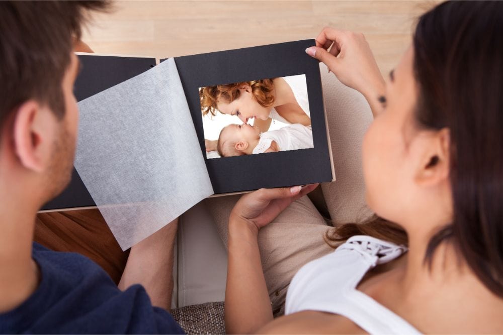 Young parents looking at a baby memory book