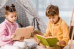 Young brother and sister reading books