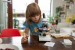 Young kid playing with microscope