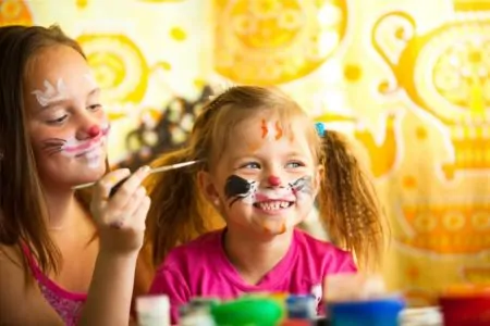 Two sisters painting their faces