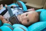 Adorable infant looking up from her blue car seat