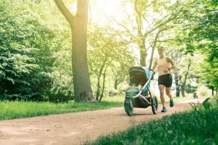 Mom jogging at the park with baby in a stroller
