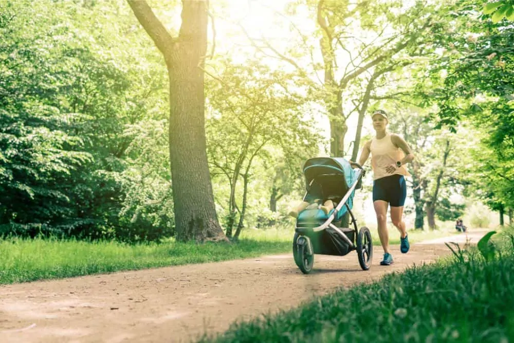 Mom jogging at the park with baby in a stroller