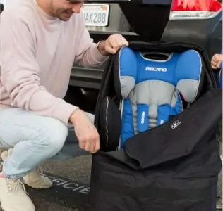 Dad taking out a car seat from its travel bag