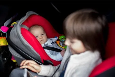 Infant in rear facing car seat watching his brother