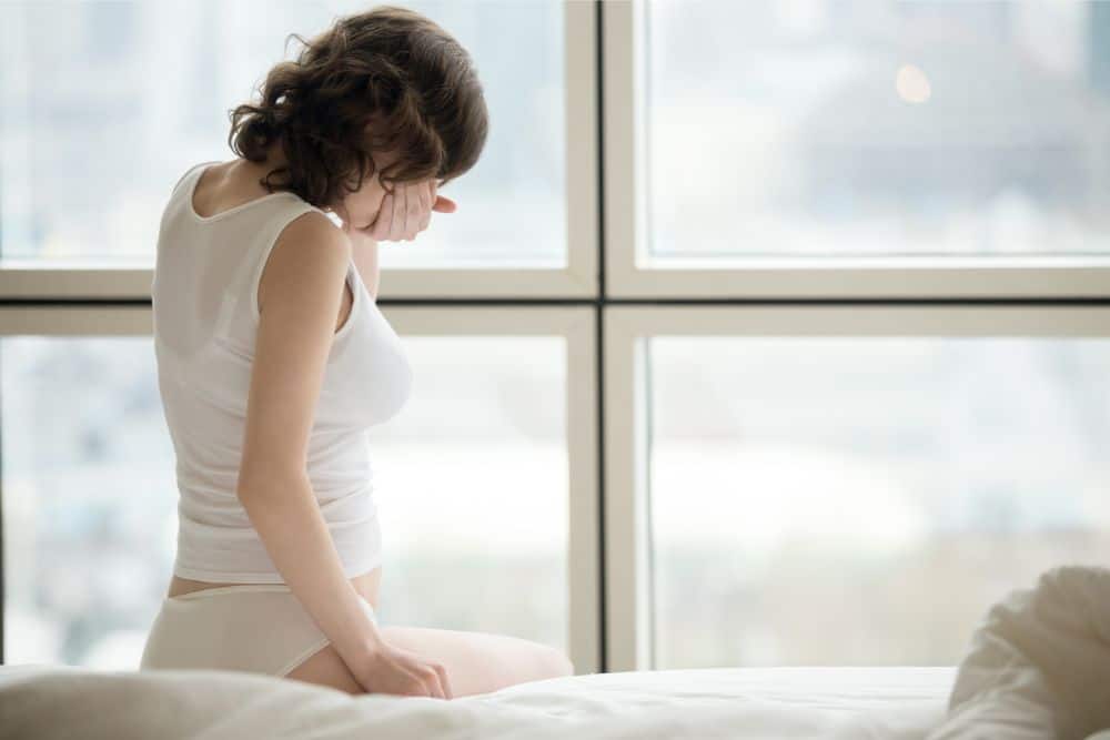 Pregnant woman feeling sick in bed