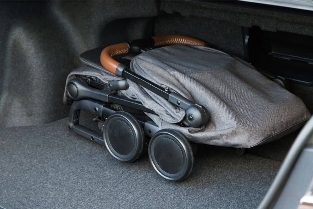 A folded stroller in the trunk of a car