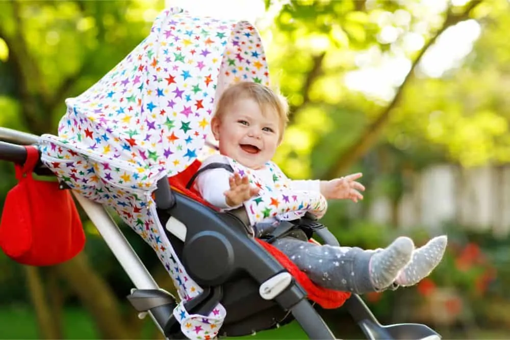 Happy baby in a stroller on a sunny day