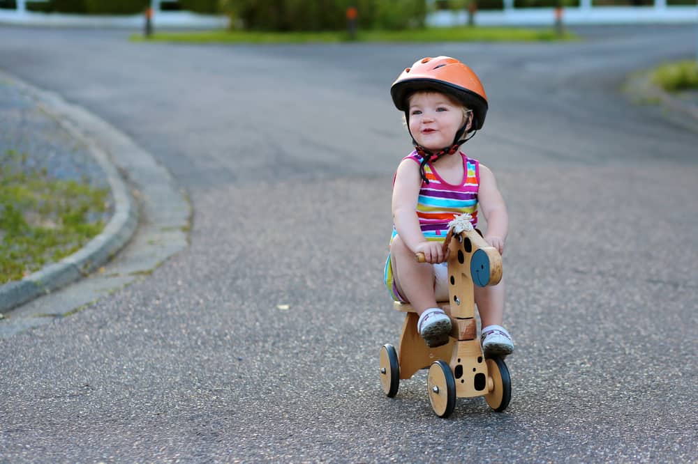 Toddler riding a bike wearing a helmet