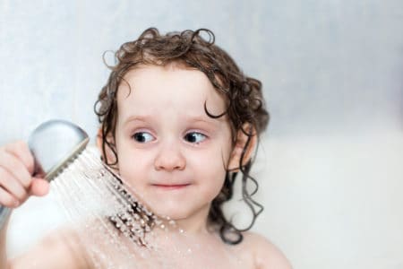 Little girl using a kids shower head