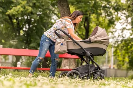 Mother checking her baby in a stroller