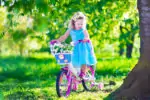 Little girl riding a pink bike