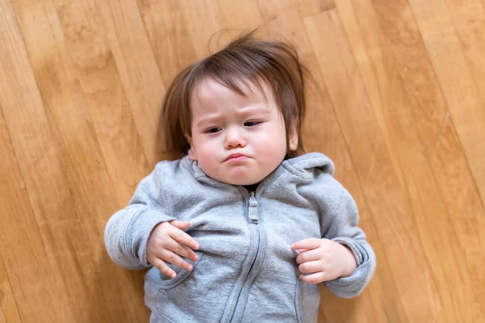 Upset toddler banging head on the floor