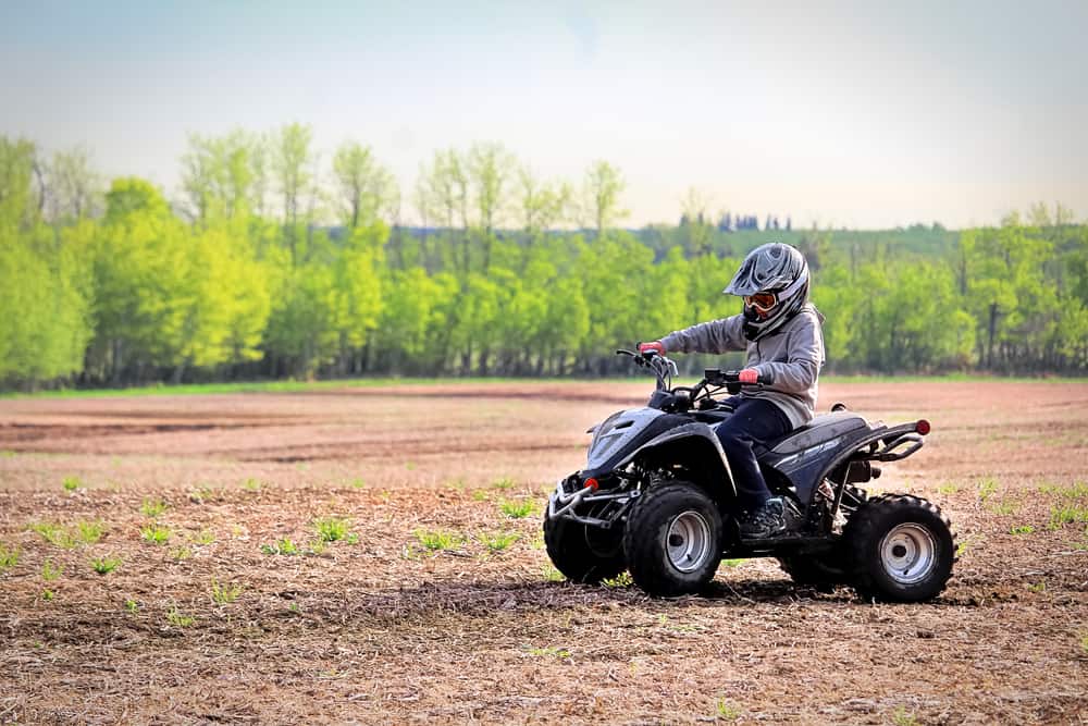 Young boy driving an ATV on a field