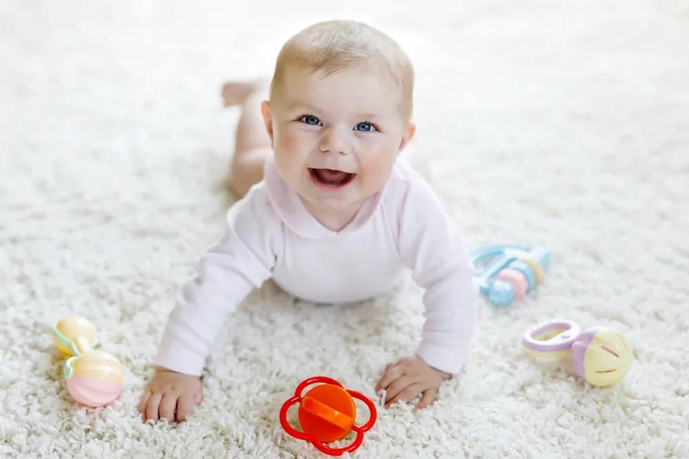 Baby happily playing with tummy time toys