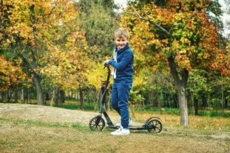 Young boy driving an electric scooter at the park
