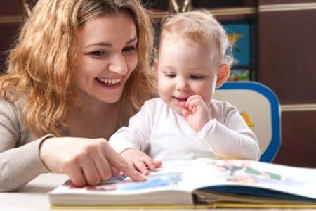 Mother reading an interactive children's book with baby daughter