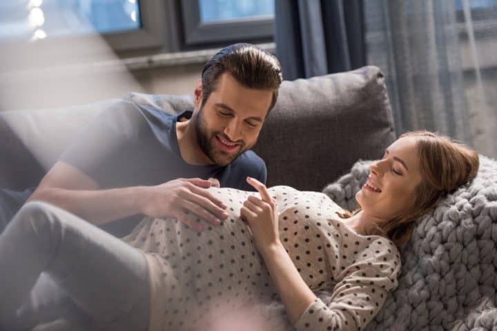 Pregnant couple lying on the couch