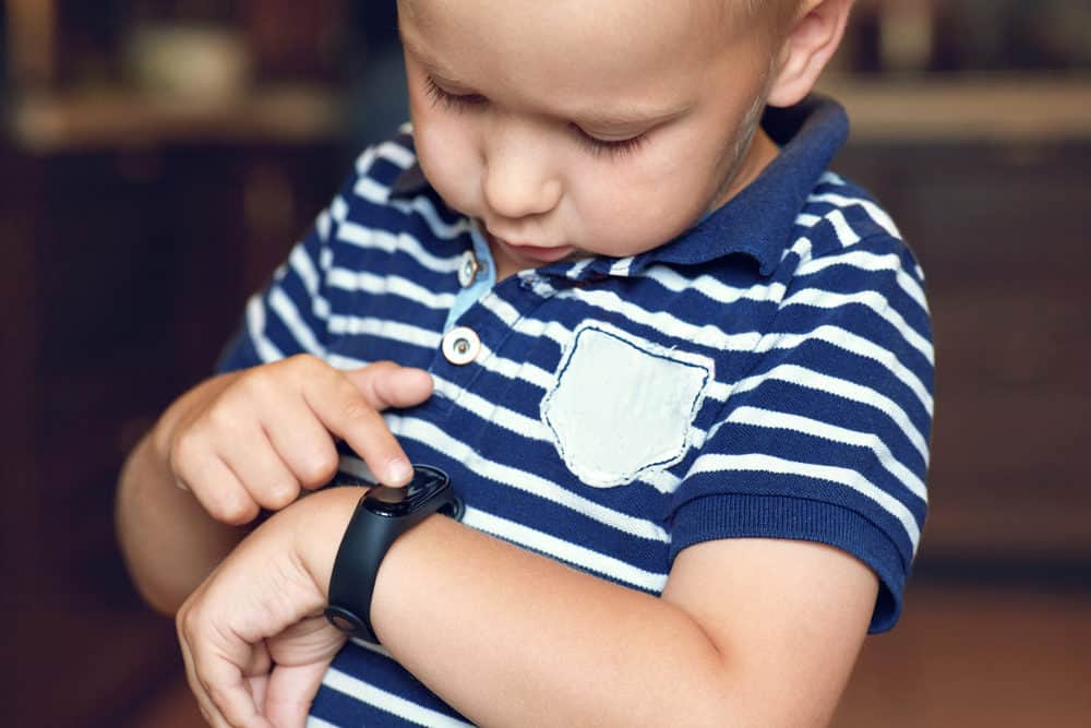 Little boy playing with his fitbit