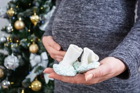 Pregnant mom preparing a baby announcement on christmas