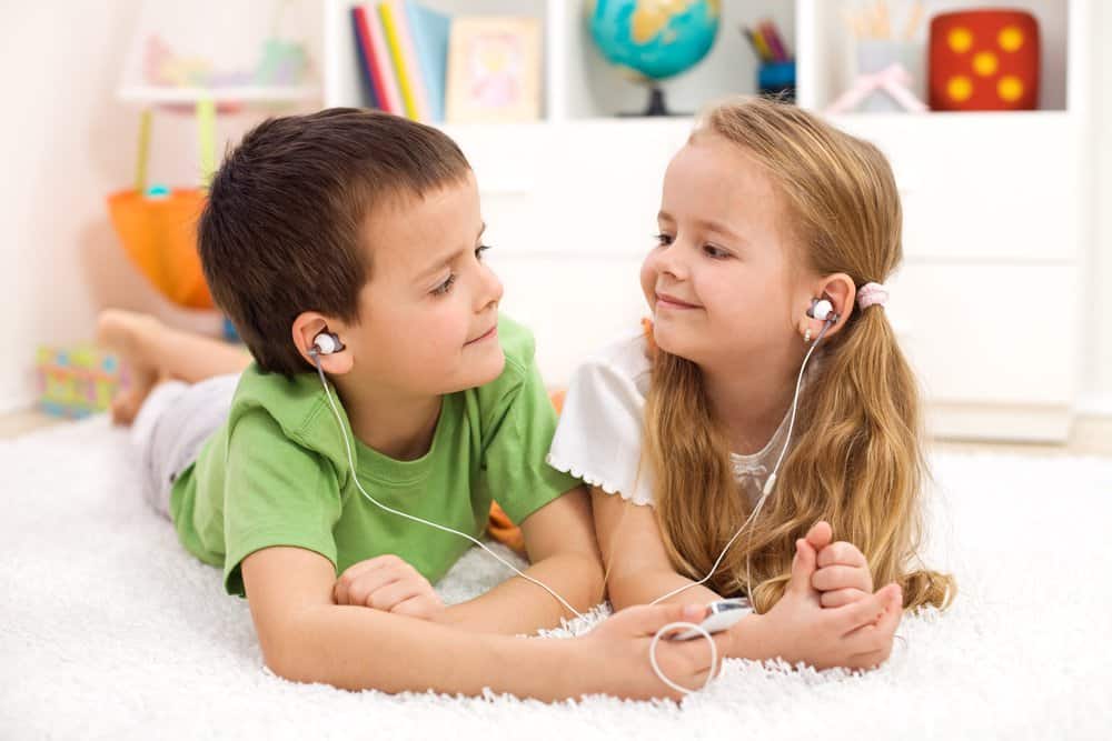 Kids sharing earphones listening from an mp3 player