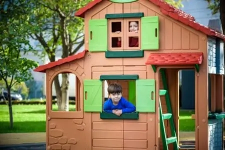 Two little boys playing in an outdoor playhouse