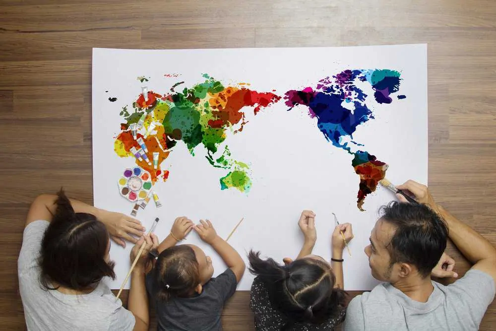 Happy happy family lying on floor with painting a world map
