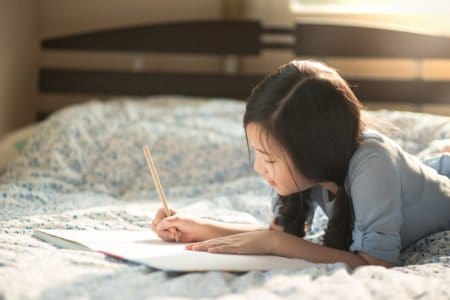 Beautiful young girl writing in her journal