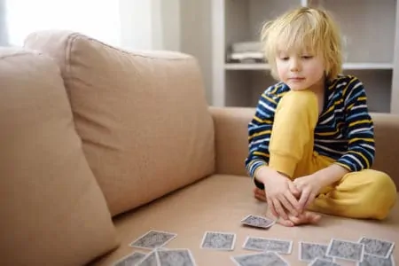 Little boy practicing a card trick