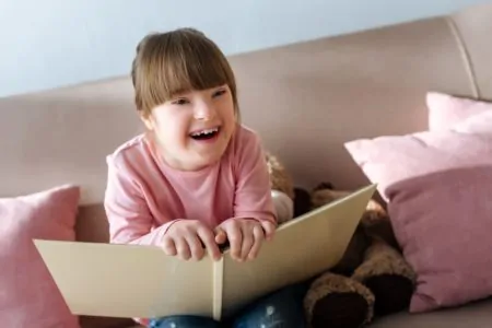Beautiful little girl laughing while reading a funny poem