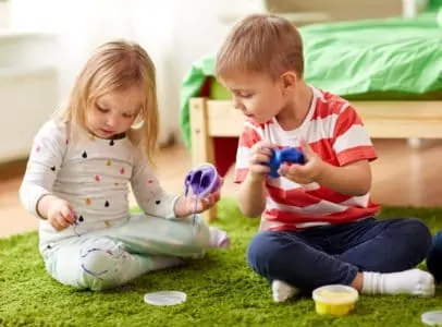 Little kids playing with slime and getting it on their clothes