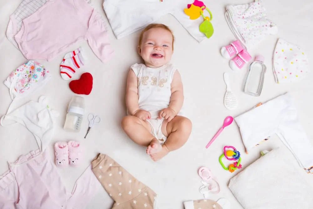 Cute baby surrounded by baby stuff