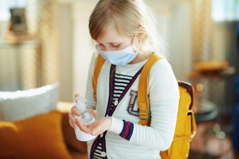 Young girl pumping hand sanitizer on her hand