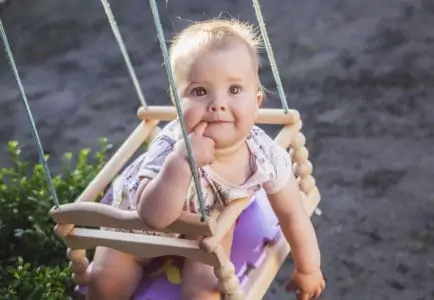 Adorable baby in an outdoor swing