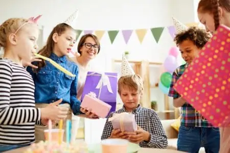 14 year old boy receiving gifts from his friends during birthday party