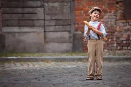 Cheerful smiling french boy with baguette